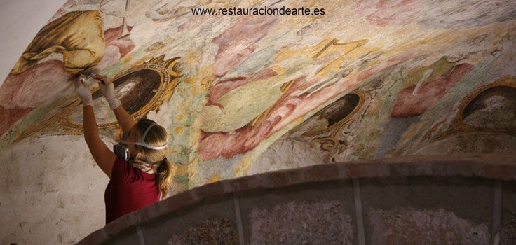 Proceso de limpieza de la capa pictórica y mortero durante la restauración de la pintura mural, realizado por la restauradora de pintura